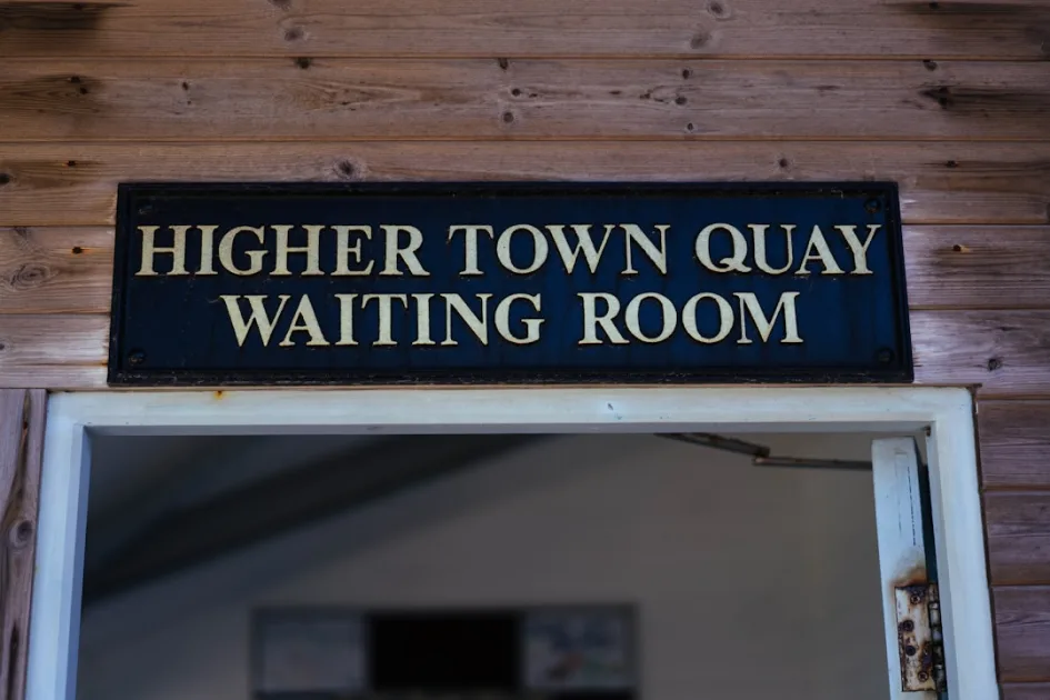 Higher town quay waiting room sign on a wooden building.